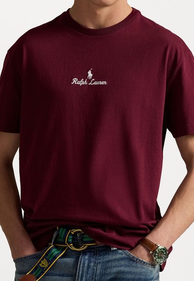 Camiseta de algodón burdeos con logo "Ralph Lauren" bordado en blanco y diseño de jugador de polo en el pecho, cuello redondo y mangas cortas.