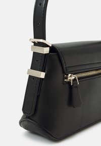 Bolso de mano de cuero negro con forma estructurada, cierre con cremallera, detalles de herrajes en tono dorado y correa ajustable.