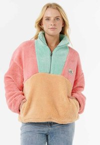 Fleece pullover in pink, mint green, and orange. Features a high collar, zip closure, and front pouch pockets. Soft texture.