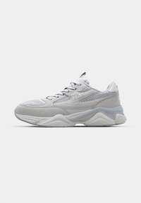 White and light grey FILA sneaker with mesh and suede panels, lace-up front, and chunky sole on a plain white background.