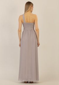 Langes, lavendelfarbenes Kleid mit einem taillierten, gerüschten Oberteil, einem Tragriemen und einem fließenden Rock. Leichte Stoffqualität und glatte Textur.