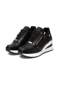 Zapatillas deportivas negras con un diseño elegante, que cuentan con un empeine de cuero, detalle de cremallera, acentos dorados y una suela de cuña blanca. Presenta paneles texturizados.