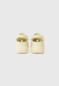 Crocs gialli con due cinturini posteriori regolabili, lati aperti e fori di ventilazione. Materiale morbido e leggero con suole texturizzate.