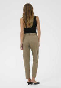 Kaki skræddersyede bukser med slim fit, der har to baglommer, en glat tekstur og afsluttede manchetter, parret med sorte hæle mules.