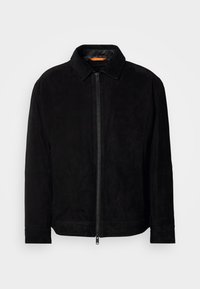 Giacca nera in suede con zip frontale, colletto e maniche lunghe, esposta su uno sfondo grigio chiaro uniforme.