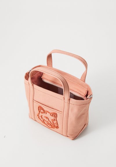 Bolsa de tela en color melocotón con dos asas superiores y cierre de cremallera. Presenta un bolsillo frontal con un diseño de zorro bordado.