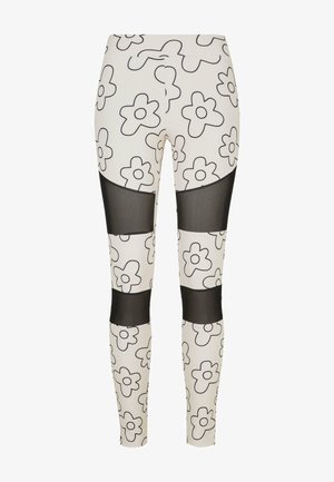 Biele legíny z látky s čiernym kvetinovým vzorom, s priesvitnými čiernymi sieťovinovými panelmi v oblasti strednej stehna a lýtok. Celkový hladký povrch.