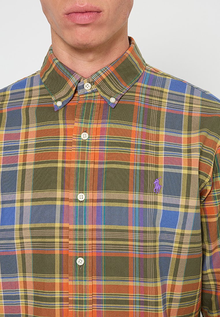 Chemise à carreaux multicolores avec des nuances de vert, orange, jaune et bleu ; col classique ; fermetures à boutons ; petit logo brodé sur la poitrine.