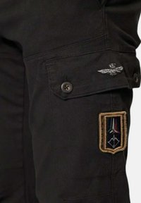 Zwarte cargobroek met een knoopzak en geborduurd embleem op het been, met een meerkleurig gedetailleerd patchontwerp.