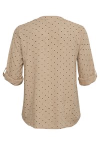 Beige košile s černými puntíky, dlouhými rukávy ohrnutými, kulatým výstřihem, měkkou látkou a volným střihem. Zadní pohled ukazuje plochý lem.