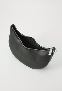 Bolso de cuero negro con forma curva, acabado texturizado, cierre superior con cremallera y logo estampado en la parte delantera. Acabados en plata.