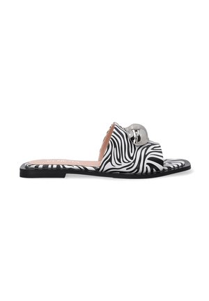 Black and white zebra print slide sandals with a rounded toe, flat sole, and a metallic accent on the upper strap. Soft inner lining visible.