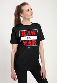 Zwart katoenen T-shirt met een opvallende rode en witte grafische tekst die luidt "RAW IS WAR" met een WWE-logo eronder.