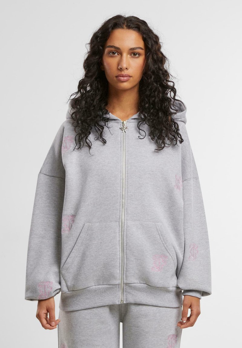 Felpa grigia con zip realizzata in un tessuto morbido, con un ampio cappuccio, tasche frontali e accenti ricamati in rosa sulla parte anteriore e sulle maniche.