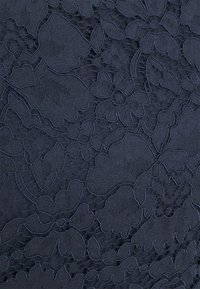 Navy blue fabric with a textured floral pattern, featuring intricate lace-like detailing and smooth sections, creating visual depth and contrast.