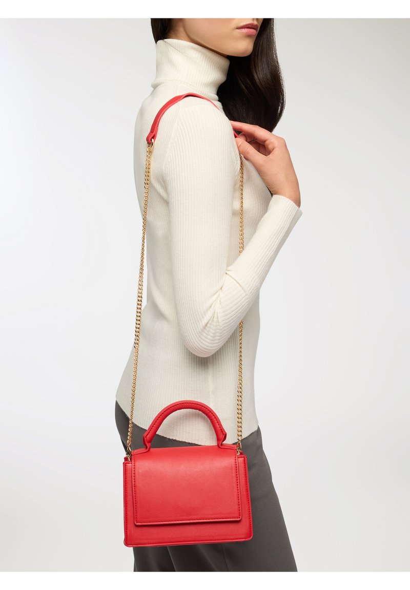 Czerwona skórzana torebka o usztywnionym kształcie, z górnym uchwytem i złotym łańcuszkiem na ramię. Gładka faktura i magnetyczne zapięcie na klapkę.