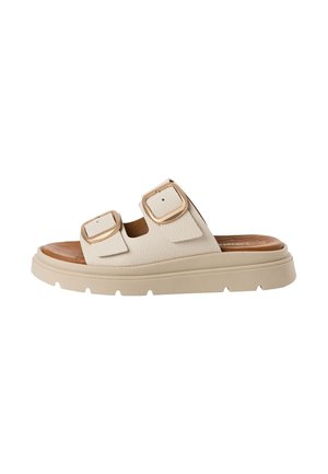 Sandale beige à enfiler avec deux sangles réglables dotées de grandes boucles dorées et une semelle épaisse avec une semelle extérieure texturée.