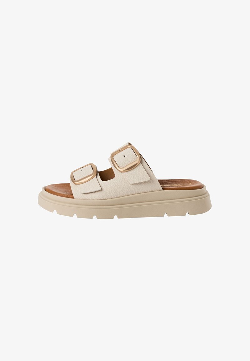 Sandale beige à enfiler avec deux sangles réglables dotées de grandes boucles dorées et une semelle épaisse avec une semelle extérieure texturée.