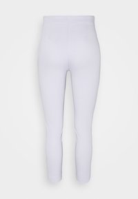 Leggings lavande clair avec une texture lisse, taille haute, coupe slim et bords ourlés. Pas de motifs visibles ni de détails en matériel.
