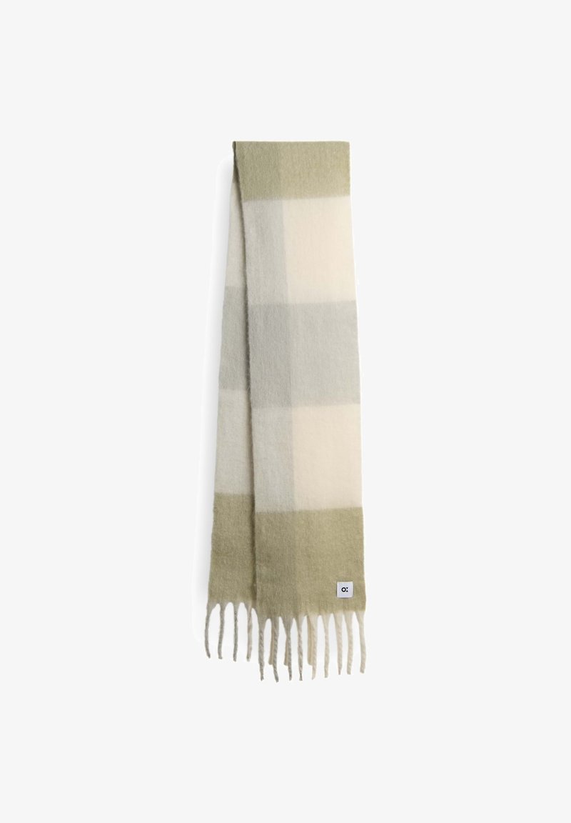 Sciarpa di lana in un motivo a quadri leggero verde, grigio e crema. Presenta bordi frangiati e un piccolo etichetta del marchio. Texture morbida.