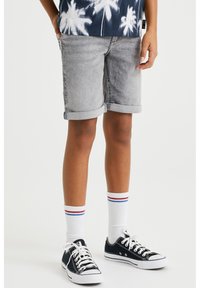 Shorts de mezclilla gris con dobladillos enrollados, combinados con zapatillas bajas negras y calcetines blancos con rayas rojas y azules.
