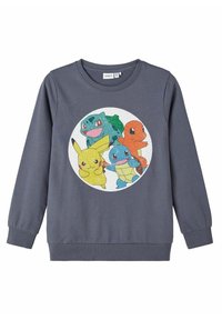 Sweatshirt gris présentant un motif circulaire avec quatre personnages Pokémon colorés : Bulbizarre, Pikachu, Carapuce et Salamèche.