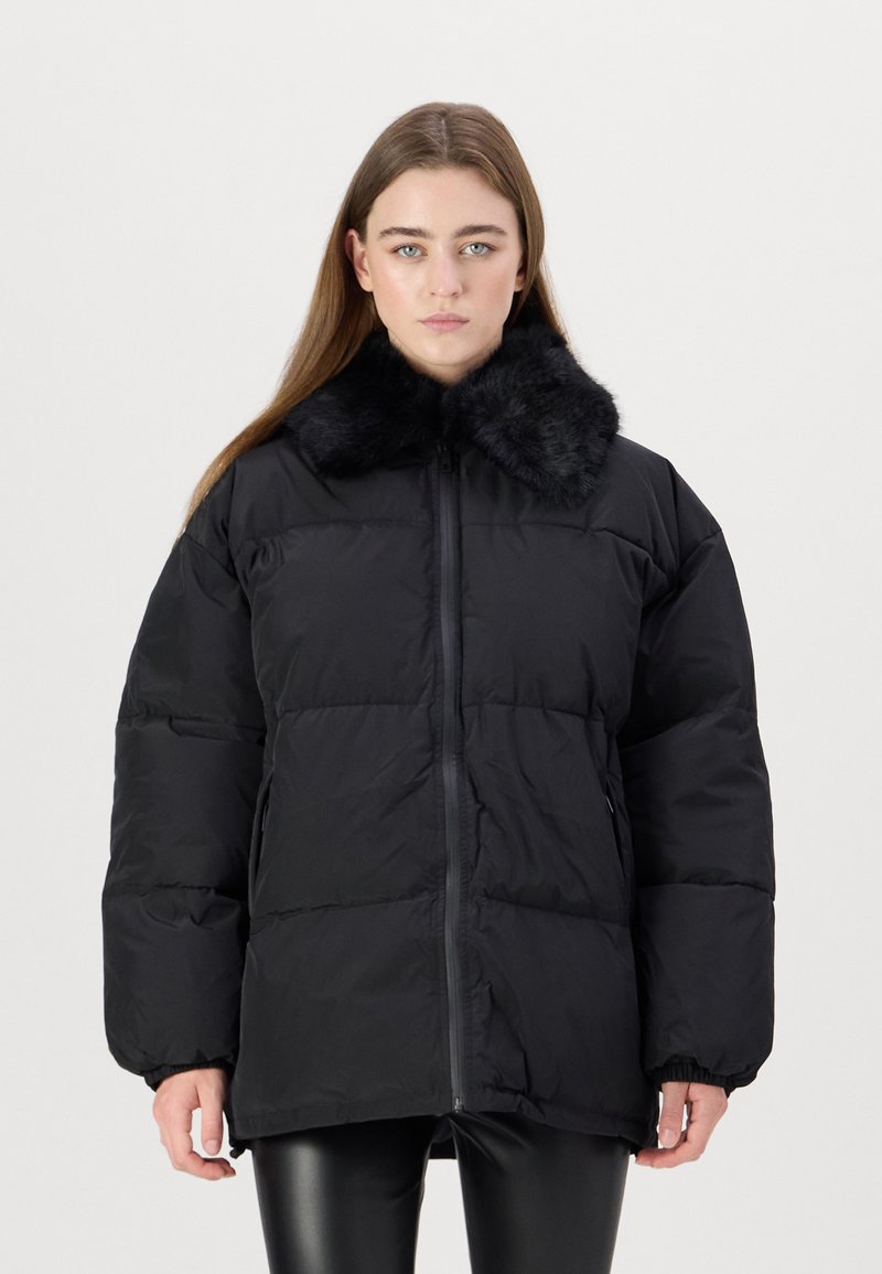 Black puffer jacket featuring a faux fur collar, zip front, and elastic cuffs. The design is oversized with a quilted texture.