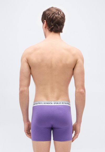 Μωβ αντρικά μποξεράκια με λευκή ελαστική μέση που φέρει την εκτύπωση "POLO RALPH LAUREN". Το ύφασμα φαίνεται λείο και εφαρμοστό.
