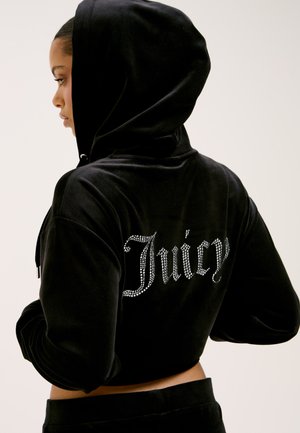 Black velvet cropped hoodie featuring rhinestone lettering "Juicy" on the back. Hooded design with long sleeves and a textured finish.