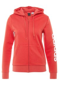Sweat à capuche corail zippé avec une poche avant, une capuche à cordon de serrage et un logo blanc imprimé le long de la manche gauche. Tissu doux et texturé.