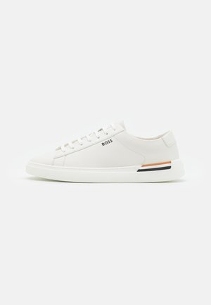 Baskets basses blanches avec lacets, logo BOSS sur le côté, et petites bandes noires et orange au-dessus de la semelle près du talon.