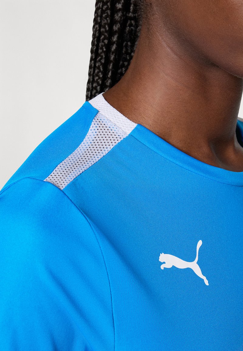 Blauw sportshirt met korte mouwen, voorzien van een wit Puma-logo en met textuurmesh accenten op de schouder voor ademend vermogen.