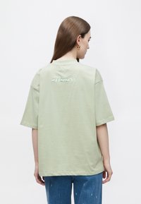 Lichtgroene oversized T-shirt met korte mouwen en een ronde hals, voorzien van een subtiel geborduurd "2NDAY" logo op de achterkant.