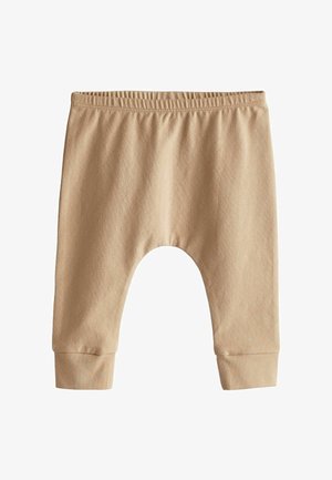 Bež bombažne hlače z elastičnim pasom, ohlapnim krojem in rebrastimi manšetami. Oblikovane so z zaobljenim krojem med nogami za udobje.