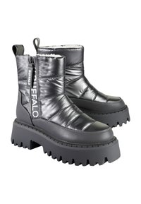 Černé péřové boty s lesklým povrchem, vybavené silnou rýhovanou podrážkou, zipem na zavírání a polstrovanými částmi pro izolaci. Součástí je také logo.