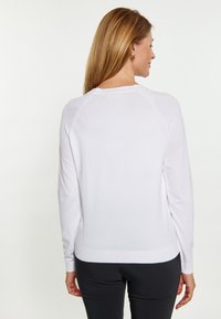 Weißer Pullover mit langen Ärmeln, gerippten Bündchen und Saum, mit rundem Halsausschnitt und nahtlosen Raglan-Schultern. Weicher, glatter Stoff.