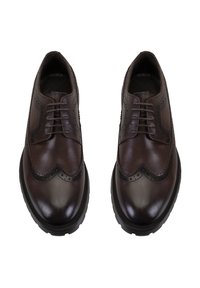 Braune Leder-Brogues mit glänzender Oberfläche, dekorativen Perforationen und einem gewellten Randdesign. Ausgestattet mit flachen Schnürsenkeln und einer Gummisohle.