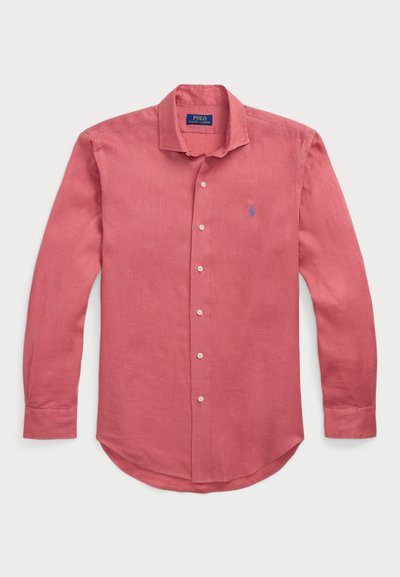 Röd linneskjorta med lång ärm som har krage med knappar, framplacket med knappar och en broderad logotyp i blått på bröstet.
