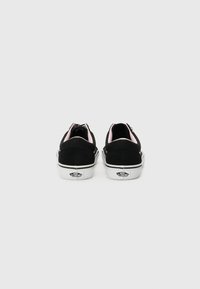 Black canvas sneakers with pink accents, white rubber soles, and logo detail on the heel. Rear view, soft texture and rounded design.