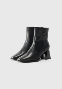 Black leather ankle boots with a pointed toe and chunky high heel. Smooth texture, minimal stitching detail, and no visible hardware.