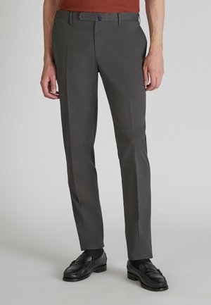 Donkergrijze broek met een slim fit, voorzien van zakken aan de voorkant, riemlussen en een soepele stoftextuur. G gedragen met zwarte leren schoenen.