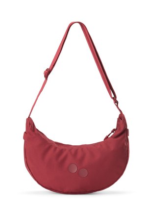 Rote schultertasche in mondförmigem Design mit verstellbarem Riemen und zwei kleinen runden Akzenten auf der Vorderseite, vor weißem Hintergrund isoliert.