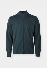 Tume roheline Nike jack, millel on kõrge krae, täispikk eesmine lukku ja pikad varrukad. Omab väikest valget logo vasakpoolses ülaservas.