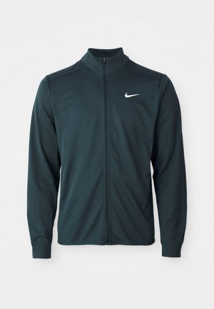 Tume roheline Nike jack, millel on kõrge krae, täispikk eesmine lukku ja pikad varrukad. Omab väikest valget logo vasakpoolses ülaservas.