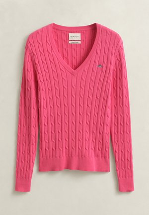 Pull rose vif en maille torsadée avec col en V, manches longues et poignets, ourlet et encolure côtelés, comportant un petit logo sur la poitrine.