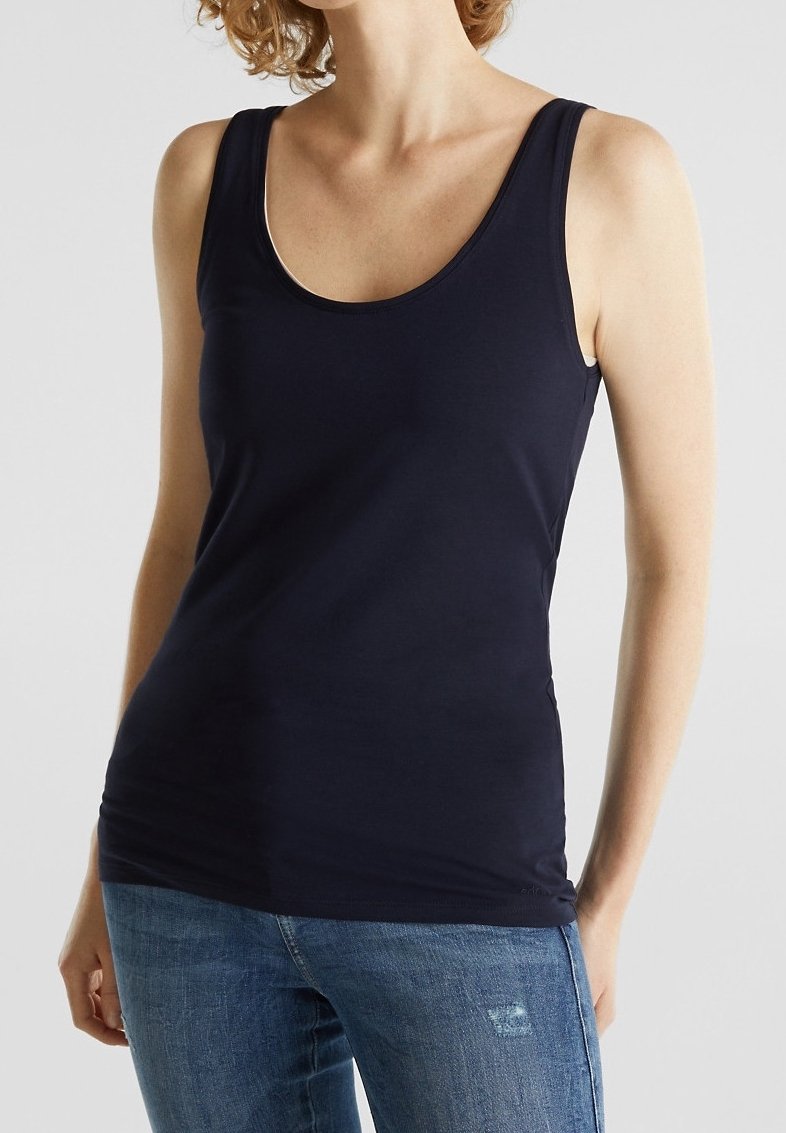 Top in cotone mélange blu navy con scollatura a girocollo e vestibilità slim. Abbinato a jeans azzurri con effetto sdrucito.