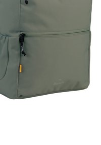 Khaki groene rugzak gemaakt van gestructureerde stof heeft een ritsvak, verstelbaar trekkoord en een "Bench" logo op de voorkant gedrukt.