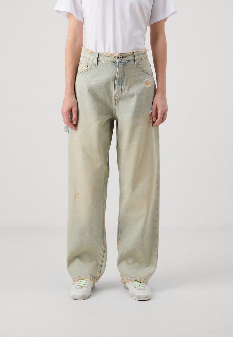 Ljusblå vida jeans med slitna detaljer, fransad midja och synlig söm. Tillverkade av bomull med en bleknad gradienteffekt.