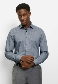 Blaues Hemd mit Knopfleiste und einem geometrischen Muster in Weiß und Rot. Lange Ärmel, schlanke Passform, strukturierter Kragen und vordere Knopfleiste.