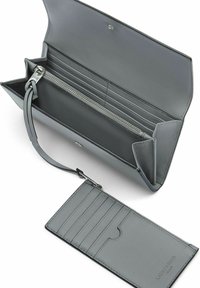 Portefeuille en cuir gris avec fermeture à zip, plusieurs emplacements pour cartes, compartiments intérieurs et bracelet détachable. Texture lisse et design minimaliste.